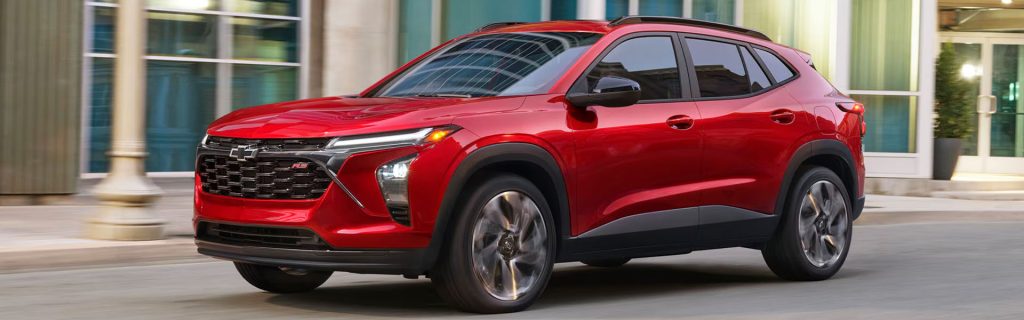 Red Chevrolet Trax driving through the city.