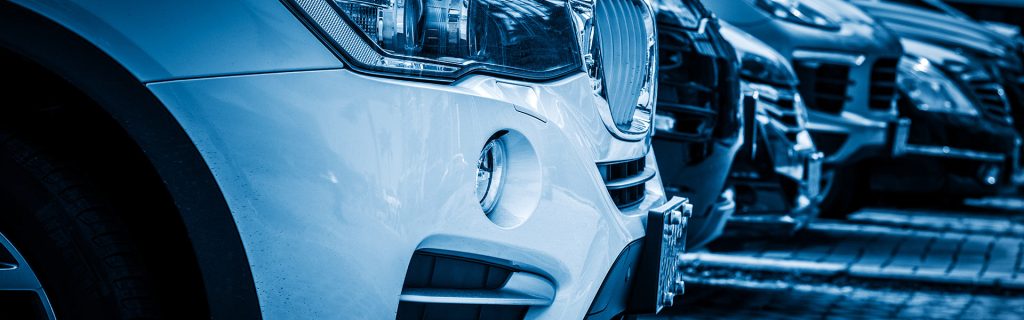 Close-up of cars parked at a dealership.