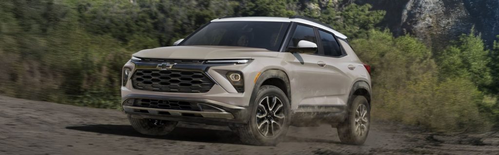 White Chevrolet SUV driving on a rugged dirt road.