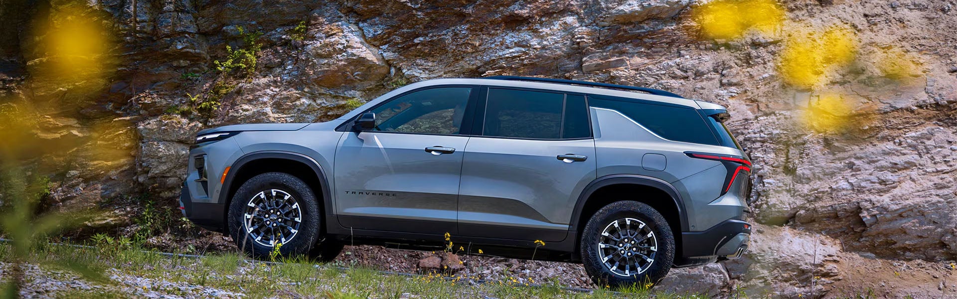 Chevrolet Traverse SUV parked near a rocky mountain landscape with rugged outdoor surroundings.