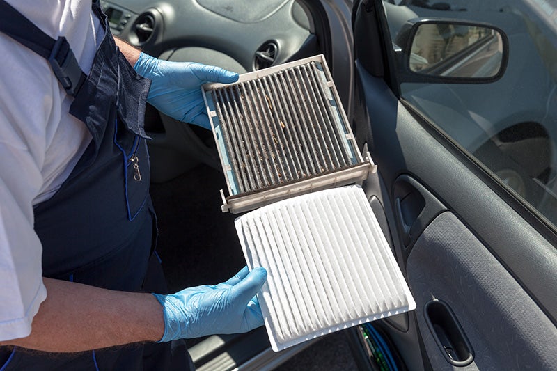 Automotive tech checking air filter