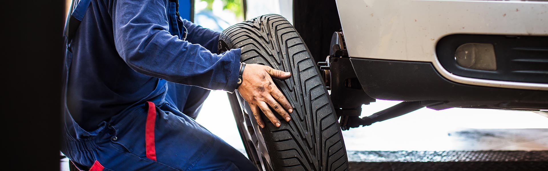 Mechanic performing a tire rotation on a vehicle.